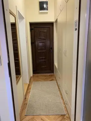 a hallway with a brown door and a rug at ANNI apartman in Paraćin
