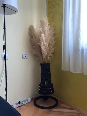 a vase with feathers in it sitting on a floor at ANNI apartman in Paraćin