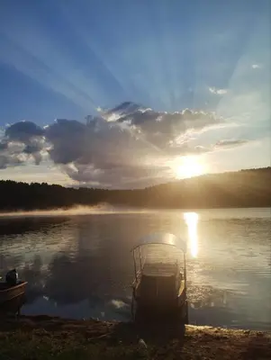 a boat sitting on the shore of a lake at Vila Krunica in Šerdanova Mahala