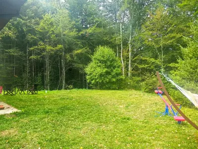 a child is flying a kite in a yard at Vila Krunica in Šerdanova Mahala