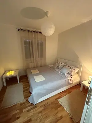 a bedroom with a bed and two rugs at Slatki Snovi - Novi apartman u centru Vranja in Vranje