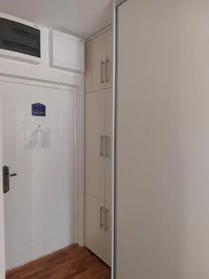 a walk in closet with a door and cabinets at Slatki Snovi - Novi apartman u centru Vranja in Vranje