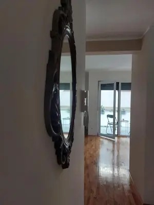 a mirror hanging on a wall in a living room at Slatki Snovi - Novi apartman u centru Vranja in Vranje