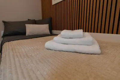 a pile of towels sitting on top of a bed at Metropolitan Royal in Jagodina