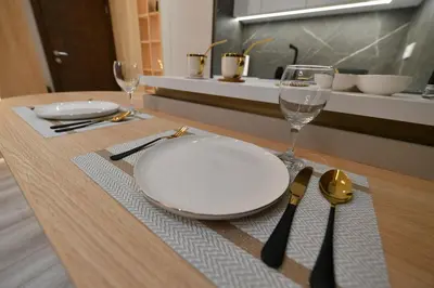 a table with a plate and wine glasses on it at Metropolitan Royal in Jagodina