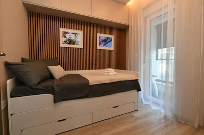 a small bedroom with a bed with a window at Metropolitan Royal in Jagodina