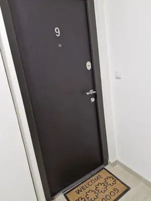 a black door with a welcome mat in front of it at Apartman Curcic 1 in Soko Banja