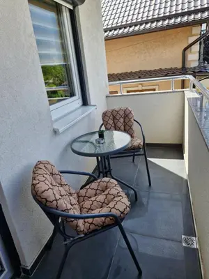 a patio with two chairs and a table on a balcony at Apartman Curcic 1 in Soko Banja