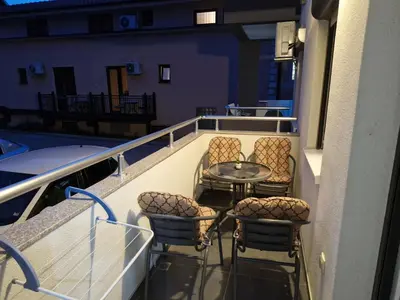 a balcony with a table and chairs on a boat at Apartman Ćurčić in Soko Banja