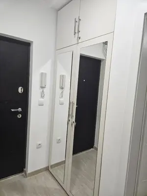 a bathroom with white cabinets and a mirror at Apartman Ćurčić in Soko Banja
