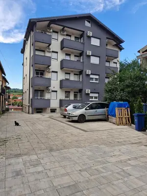 a building with a car parked in front of it at Apartman Ćurčić in Soko Banja