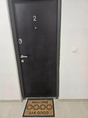 a black door with a welcome mat in front of it at Apartman Ćurčić in Soko Banja