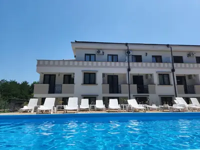 a building with chairs and a swimming pool at Apartman NIKA Vrnjačka Banja in Vrnjačka Banja
