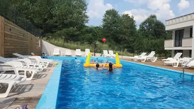 two people are playing in a swimming pool at Apartman NIKA Vrnjačka Banja in Vrnjačka Banja