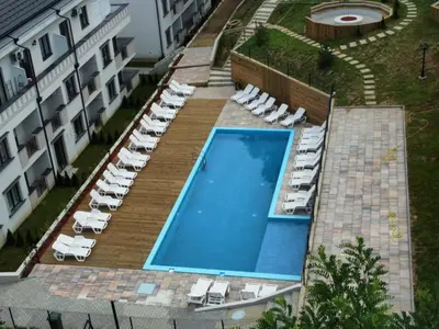 an overhead view of a swimming pool with lounge chairs and a hotel at Apartman NIKA Vrnjačka Banja in Vrnjačka Banja