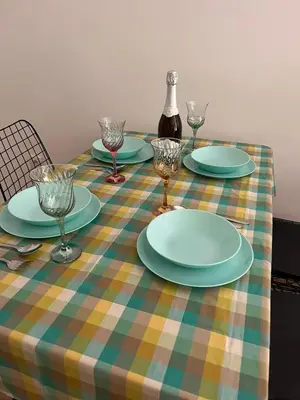a table with plates and glasses and a bottle of wine at Apartman NIKA Vrnjačka Banja in Vrnjačka Banja