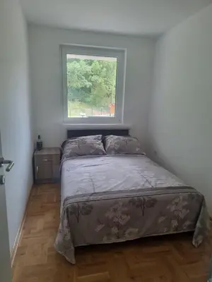 a bed in a bedroom with a window at Apartman NIKA Vrnjačka Banja in Vrnjačka Banja