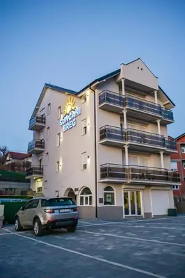 a building with a car parked in a parking lot at Suncani Breg in Soko Banja