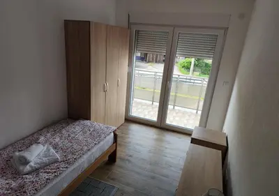 a bedroom with a bed and a sliding glass door at Suncani Breg in Soko Banja