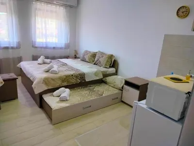 a small bedroom with two beds and a refrigerator at Studio Marija 21 in Soko Banja