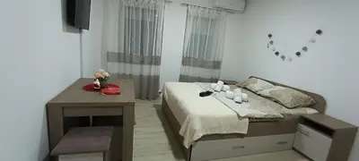 a small bedroom with a bed and a table at Studio Marija 21 in Soko Banja