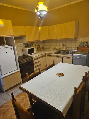 a kitchen with a table and a sink and a refrigerator at Apartmani,,Drljaca,,1 in Soko Banja
