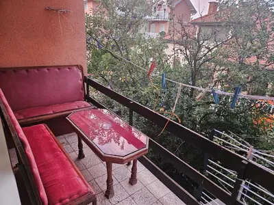 a red bench and a table on a balcony at Apartmani,,Drljaca,,1 in Soko Banja