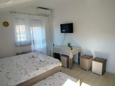 a bedroom with two beds and a table and a television at Studio Marija 20 in Soko Banja
