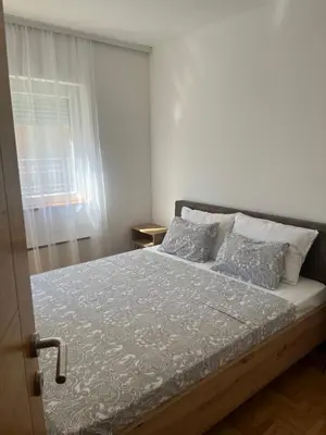 a bed in a white room with a window at Apartman Anja in Vrnjačka Banja