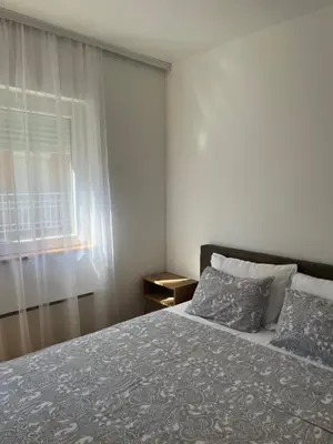 a bedroom with a large bed and a window at Apartman Anja in Vrnjačka Banja