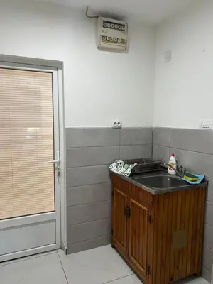 a small kitchen with a sink and a door at Apartman Soni Jagodina- free jacuzzi, private parking, pet friendly in Kolonije