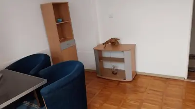 a living room with two blue chairs and a table at Apartman EmEm in Kuršumlija