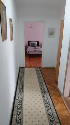a bedroom with a bed and a rug on the floor at Apartman EmEm in Kuršumlija