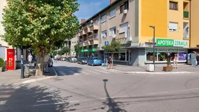a city street with people walking down the street at Apartman EmEm in Kuršumlija