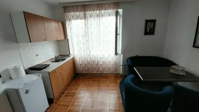 a small kitchen with a sink and a table and chairs at Apartman EmEm in Kuršumlija