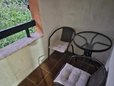 a table and a chair in a room with a window at Apartmani,,Drljaca,,4 in Soko Banja