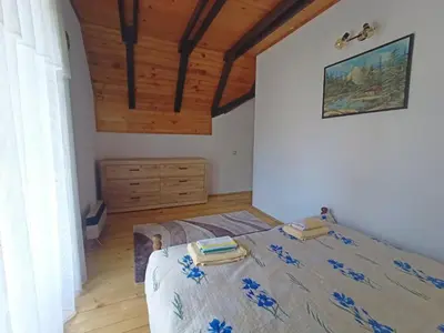 a bedroom with a bed and a wooden ceiling at Vlasinsko jezero vila BiLiV in Surdulica