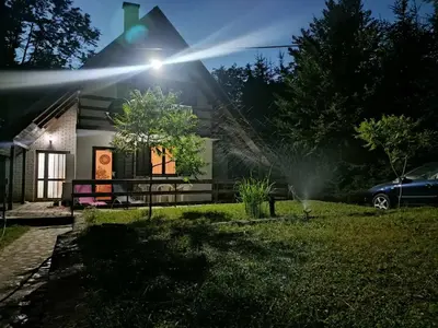 a house with a sprinkler in the yard at Vlasinsko jezero vila BiLiV in Surdulica