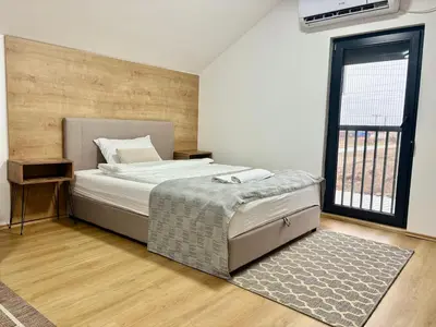 a bedroom with a bed and a large window at Promo Studio Apartment in Pirot