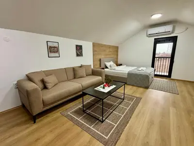 a living room with a couch and a bed at Promo Studio Apartment in Pirot