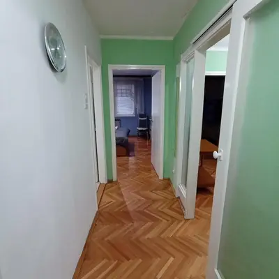 a hallway with green walls and a wooden floor at Apartman Icić in Pirot