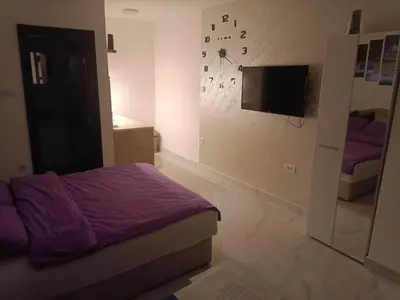 a bedroom with a bed and a tv on a wall at Night-DUBLE MM 2 in Leskovac