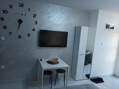 a room with a table and a clock on the wall at Night-DUBLE MM 2 in Leskovac