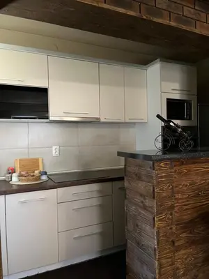 a kitchen with white cabinets and a counter top at Delux apartman in Leskovac