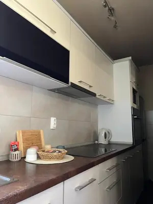 a kitchen with white cabinets and a counter top at Delux apartman in Leskovac