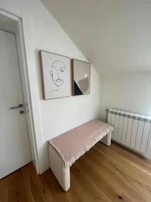 a white room with a bench with a picture on the wall at Villa Sienna in Vrnjačka Banja