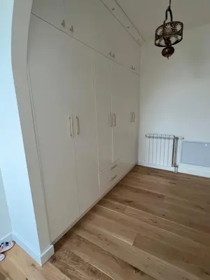 a room with white cabinets and a wooden floor at Villa Sienna in Vrnjačka Banja