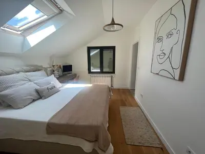 a bedroom with a large bed and a skylight at Villa Sienna in Vrnjačka Banja