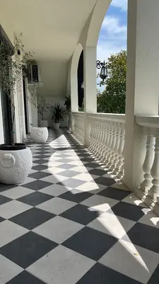 a white porch with a black and white checkered floor at Villa Sienna in Vrnjačka Banja