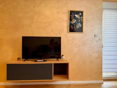 a living room with a flat screen tv on a wall at Luxe Apartman Sokobanja in Soko Banja